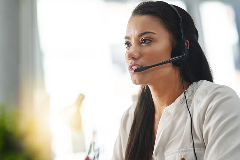 Female support agent using Dynamics 365 Customer Service to help resolve a customer issue