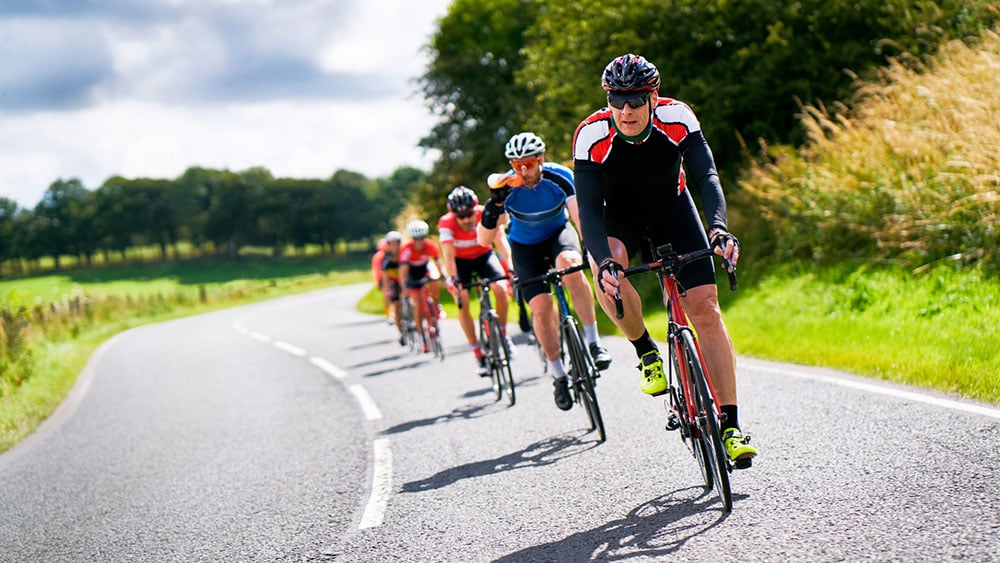 Sunny day with a group of cyclists on a clear road